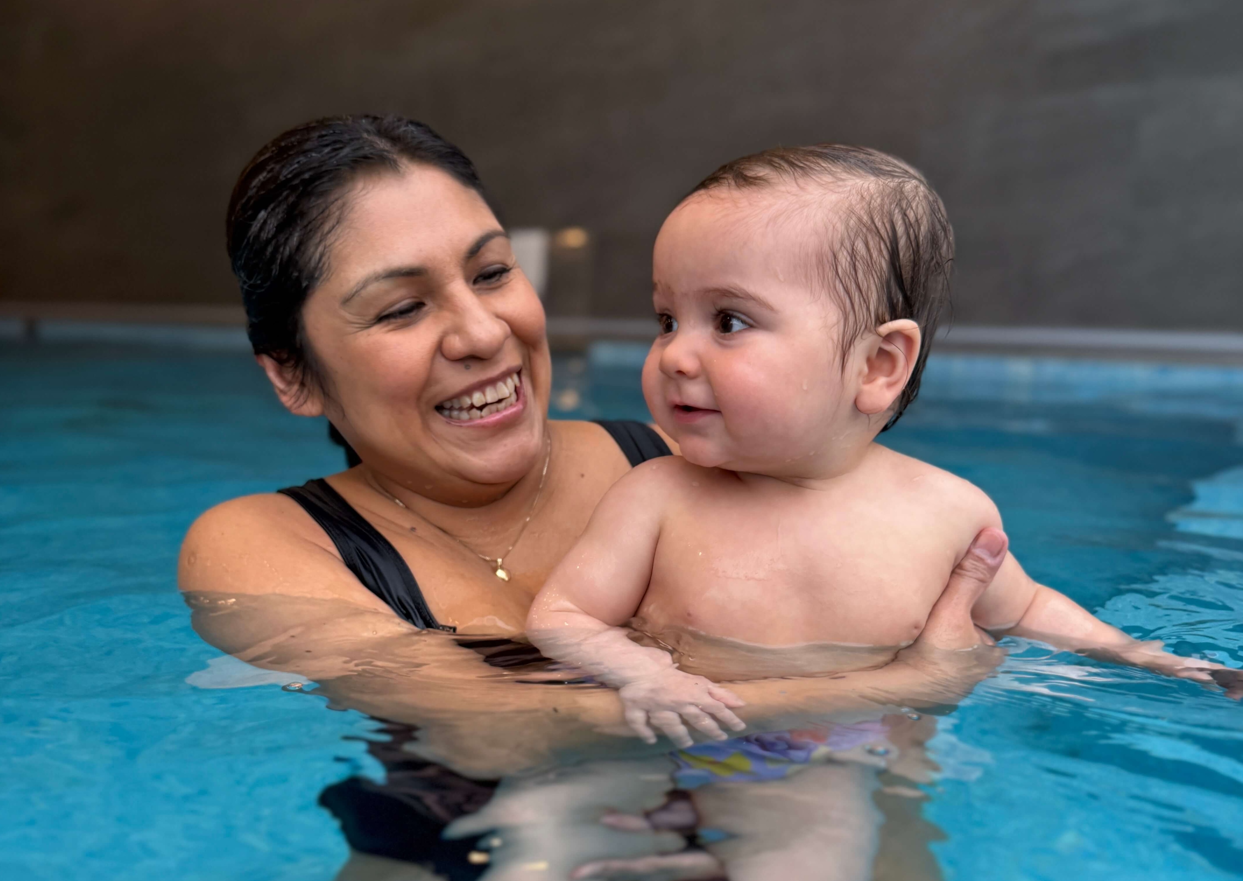 Mamma med bebis på vattenkompaniet i bassängen